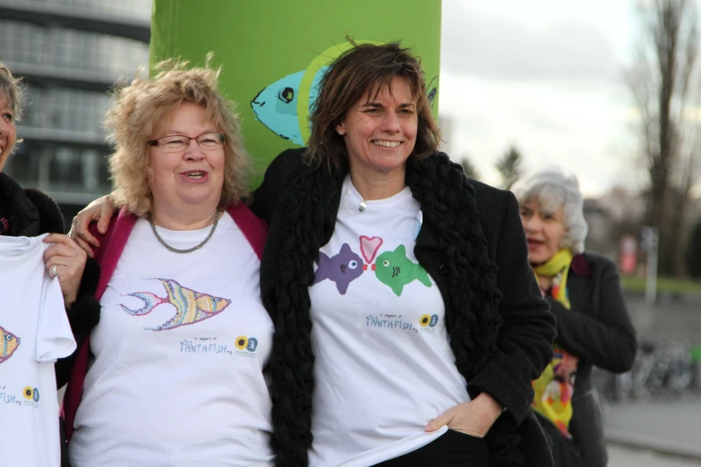 two women pose for a po holding up shirts