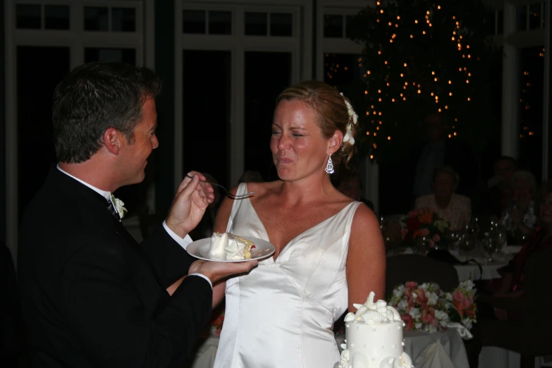 a beautiful woman in a dress standing next to a man