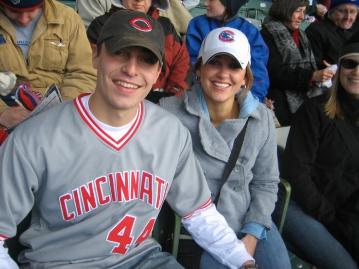 two people sitting at a baseball game together