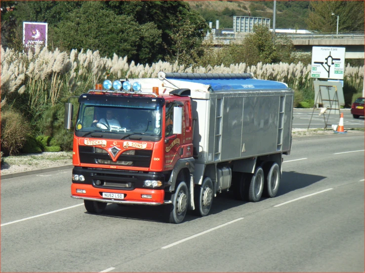 a big truck is on the road near a grassy area