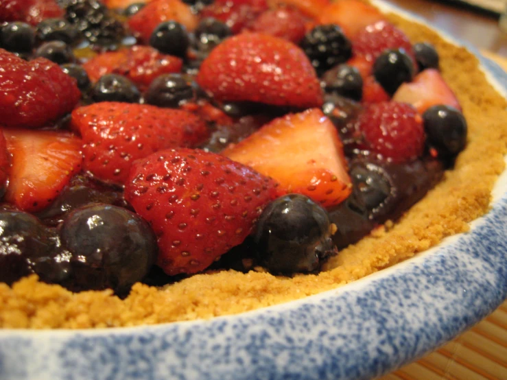 a dessert topped with berries and blueberries in a dish