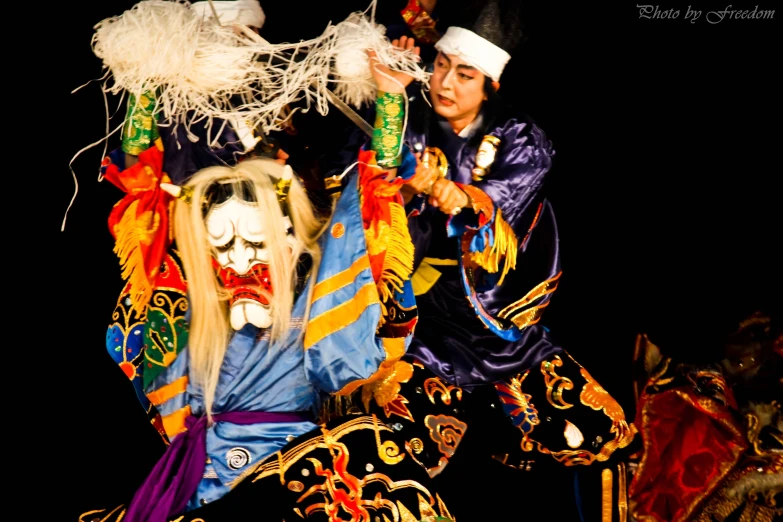 two people performing in costume on black background