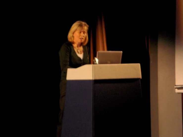 a woman that is standing behind a blue and white podium