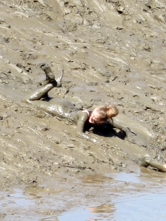 the man is laying on his side in the mud