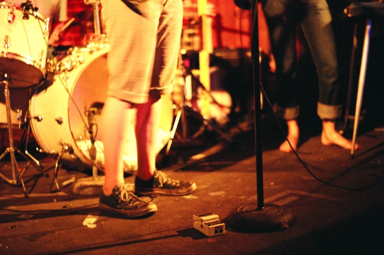 a person wearing sneakers stands on a stage next to a microphone