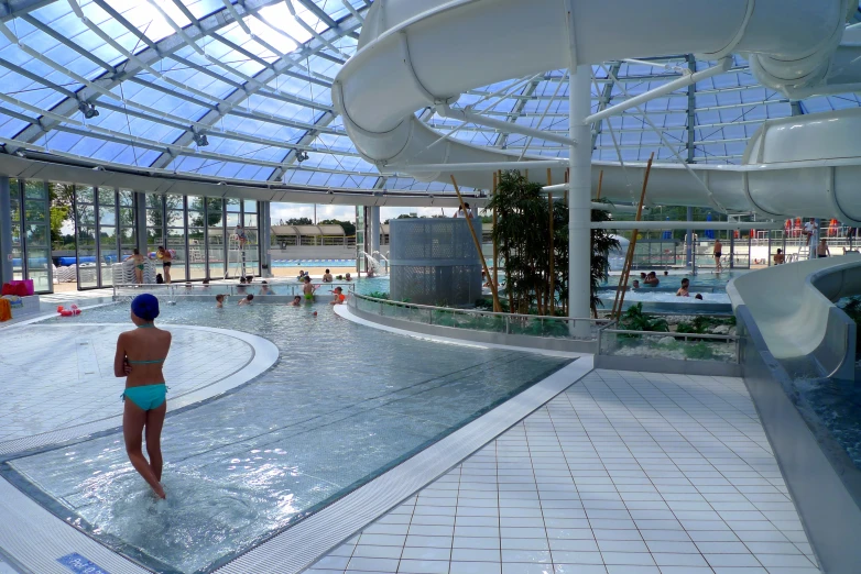 a women who is standing in a pool near some water