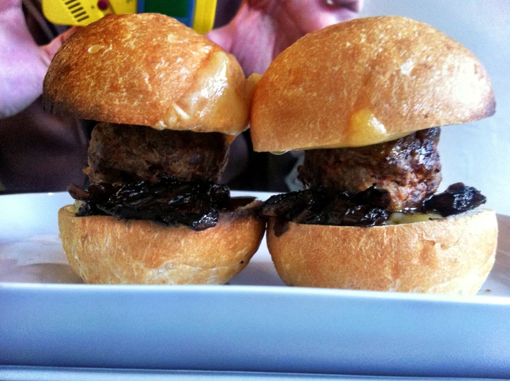 a man taking a picture of some sandwiches