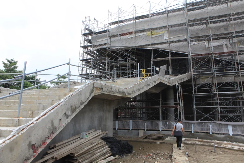 a man walks down some steps near a concrete structure