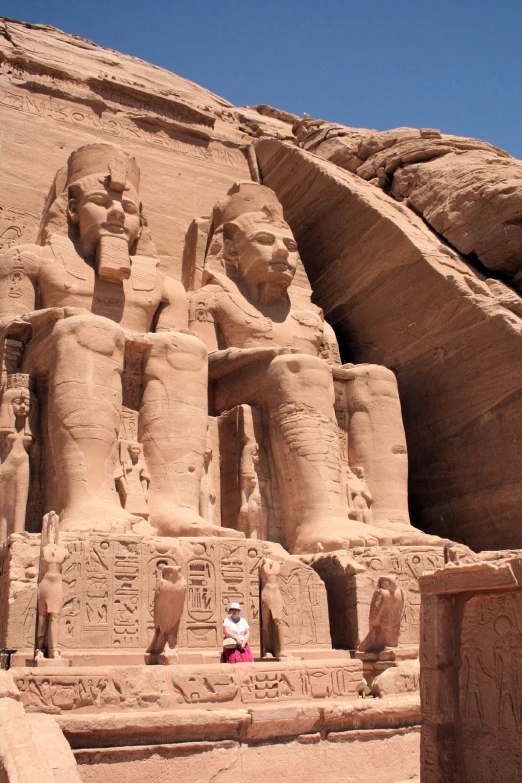 ancient statue in middle of desert area near mountains