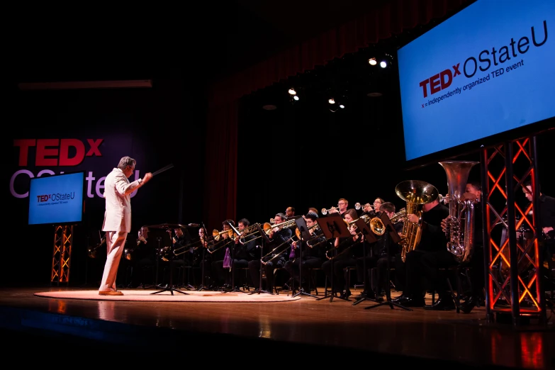 a woman on stage is talking and the music is performing