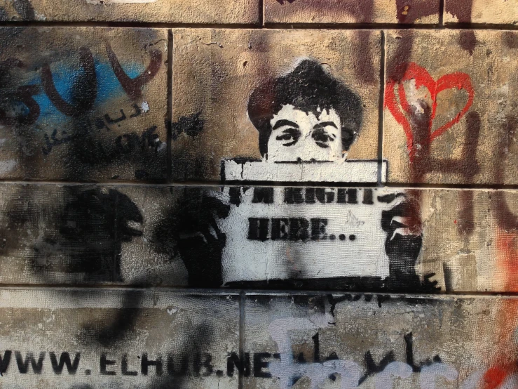 graffiti on the wall shows a person holding a sign