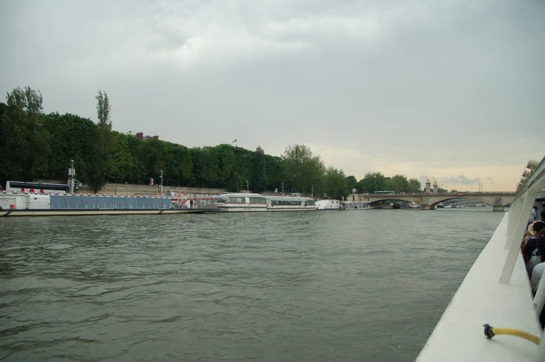 boats in the water near a shore on a cloudy day