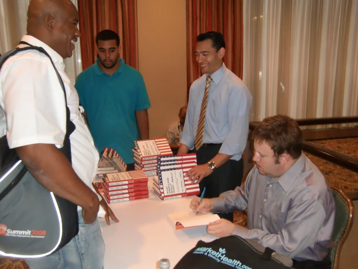 several people standing around a table with boxes and a briefcase