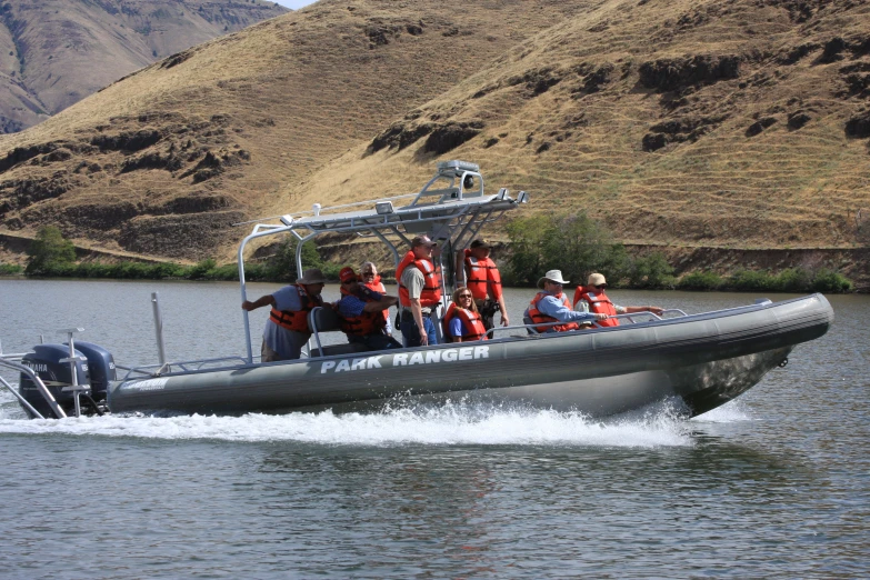 group of people riding in an aluminum boat on water