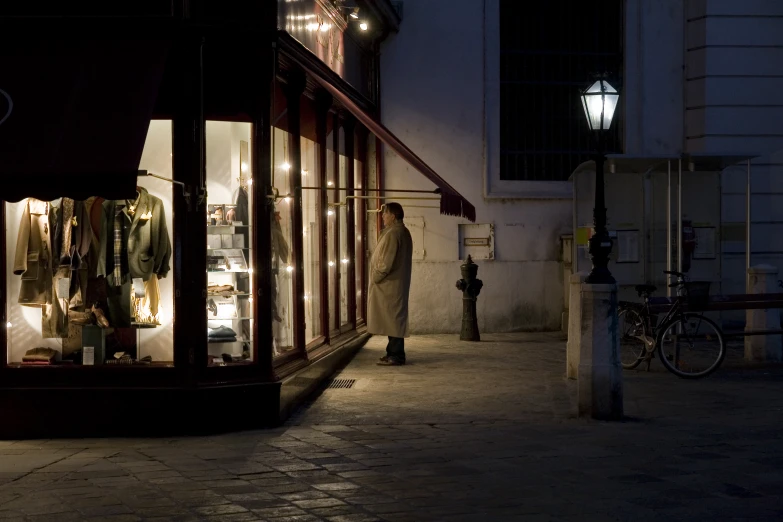 a person in front of a store with a lit up window