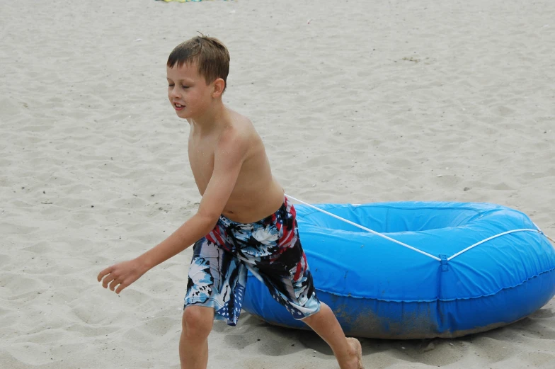 a little boy that is standing in the sand