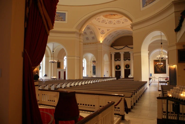 an empty aisle with rows of chairs and windows