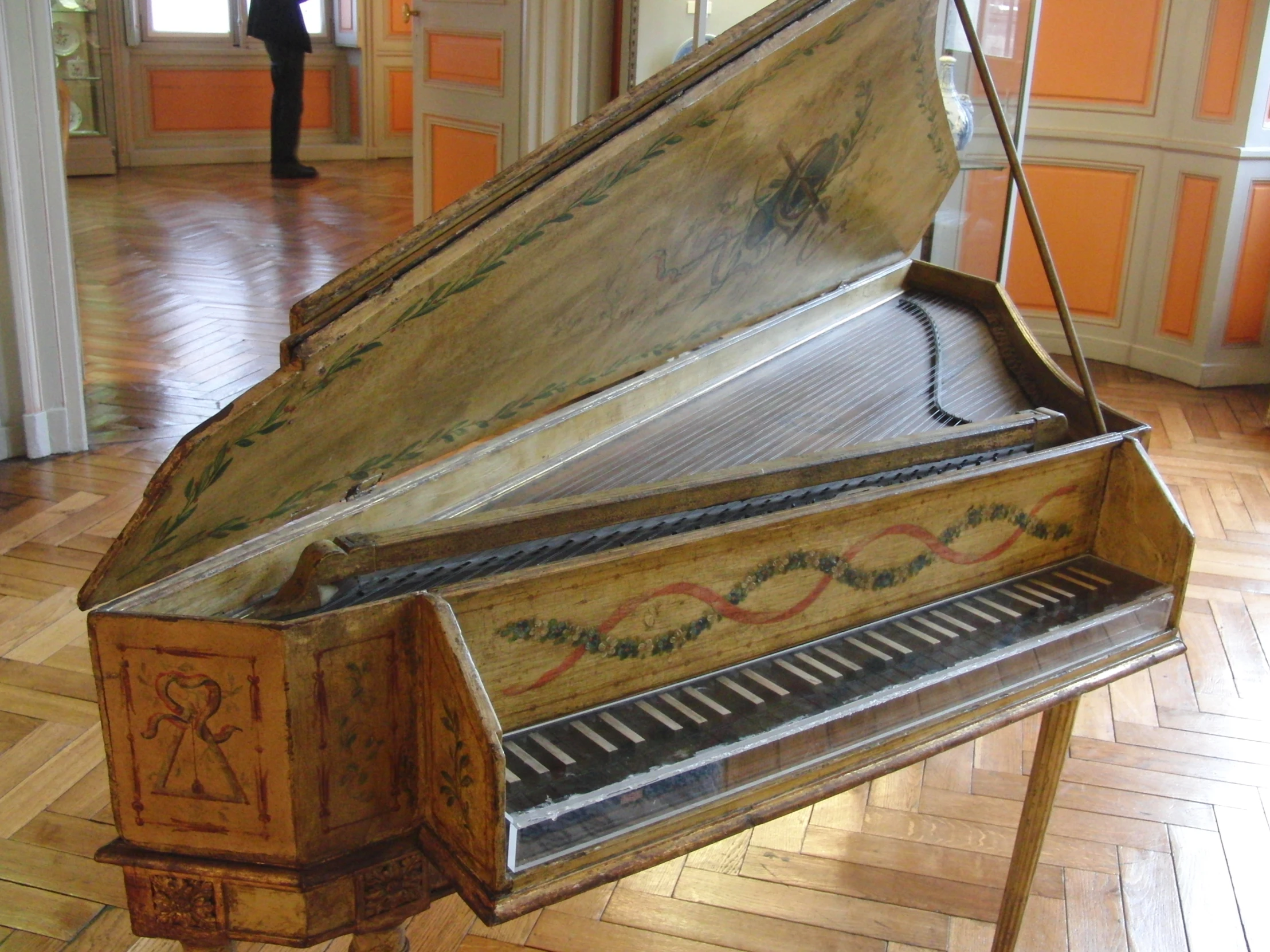 a wooden piano with ornate designs sits in an empty room