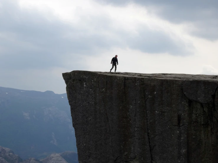 two people on top of a cliff looking at the sky