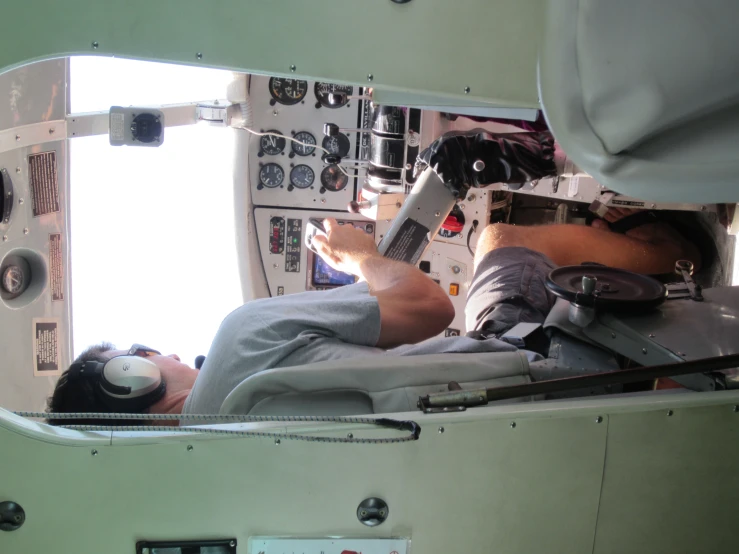 a man holding a camera in the cockpit of an airplane