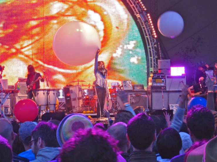 the crowd of people in front of a stage playing musical