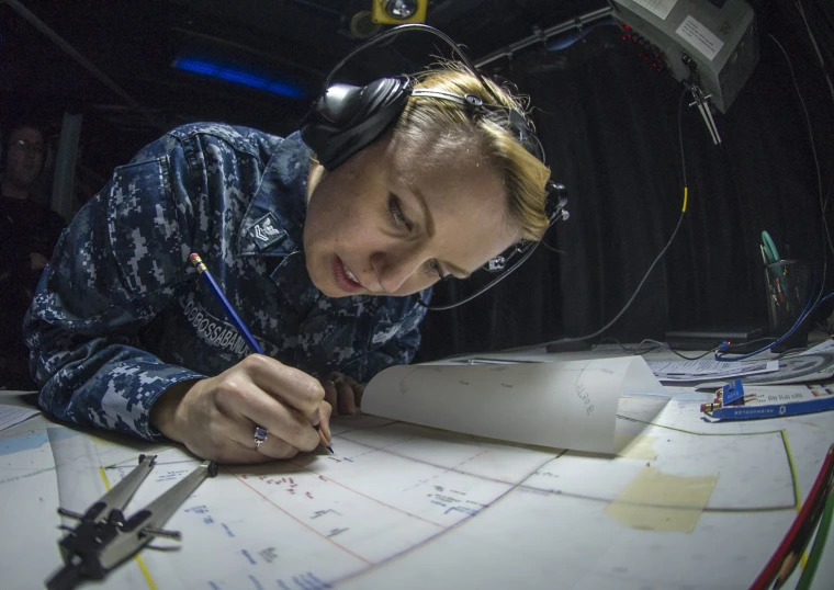 a female in camouflage is working on an aircraft