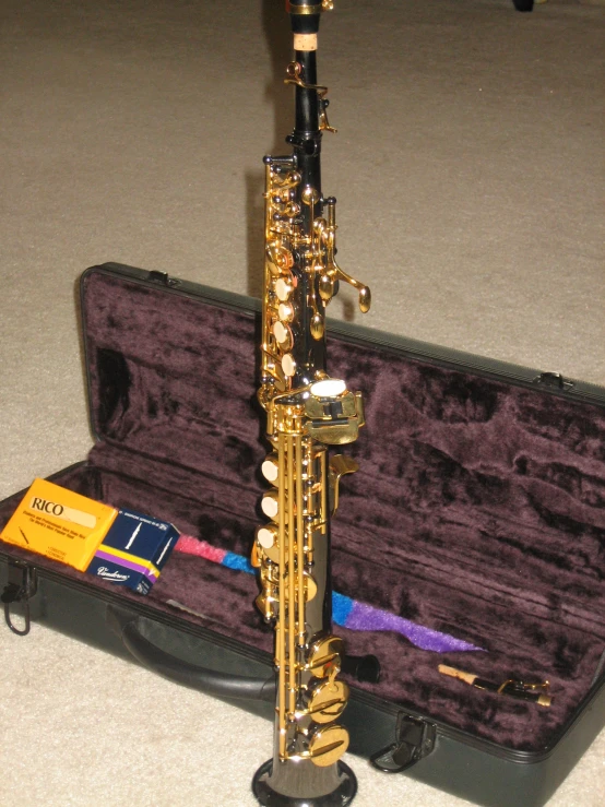 a wooden flute sitting on the floor next to a piece of luggage