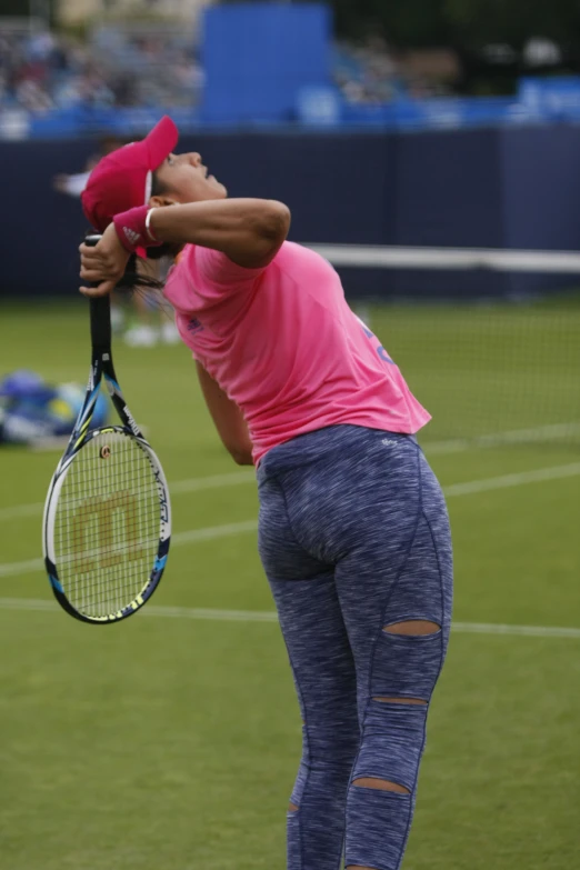 a woman wearing blue and pink swinging a tennis racquet