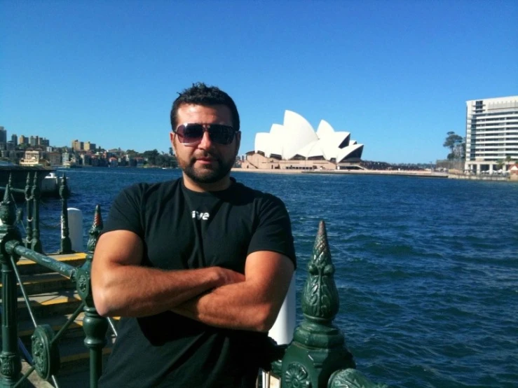 a man standing by a railing by the ocean