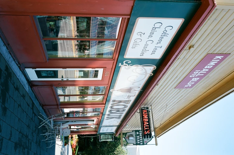 a street with a sign on the side and the building has a red roof