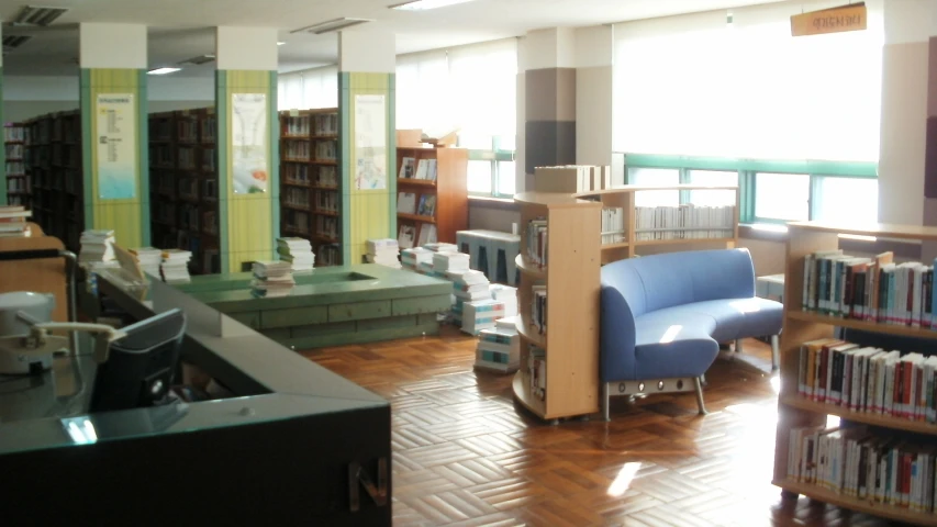 the large liry has some blue chairs, and several books