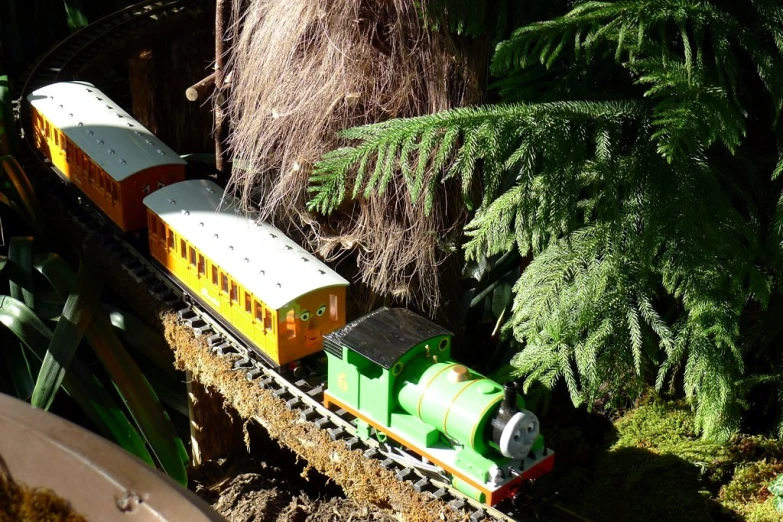 an image of a toy train set that is set in a garden