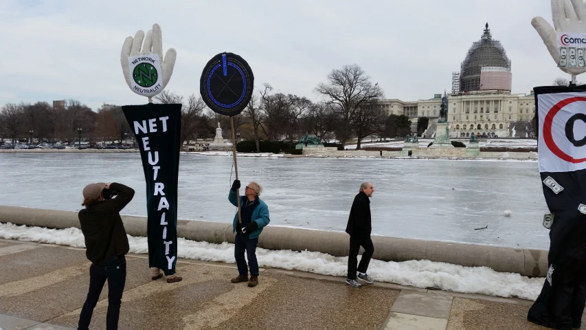 a group of people hold up protest signs on the side of the river