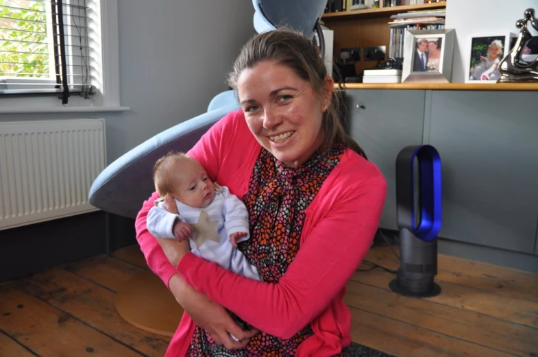 a woman with a child holding a surfboard