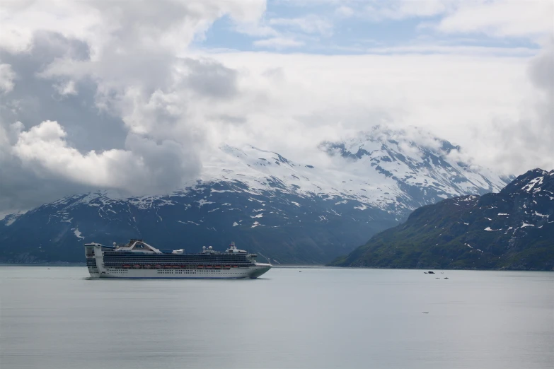 a cruise ship is in the middle of a large lake near mountains