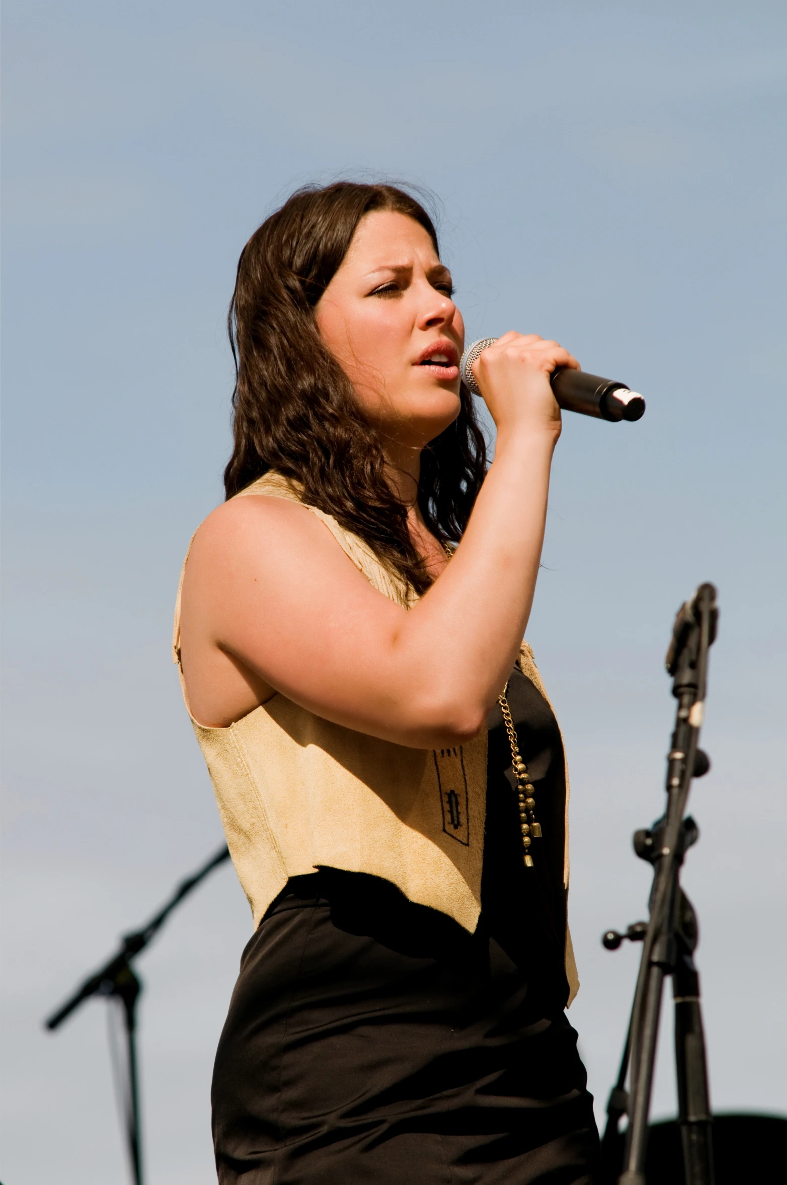 the woman is holding a microphone and singing