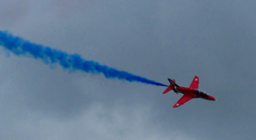 a jet flying in the sky with smoke trailing from it