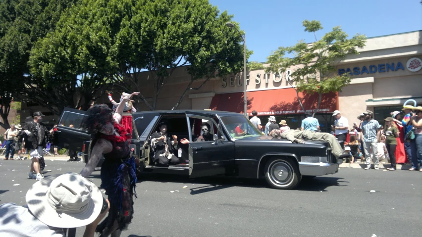 people walking around in the street and near cars with their hats on