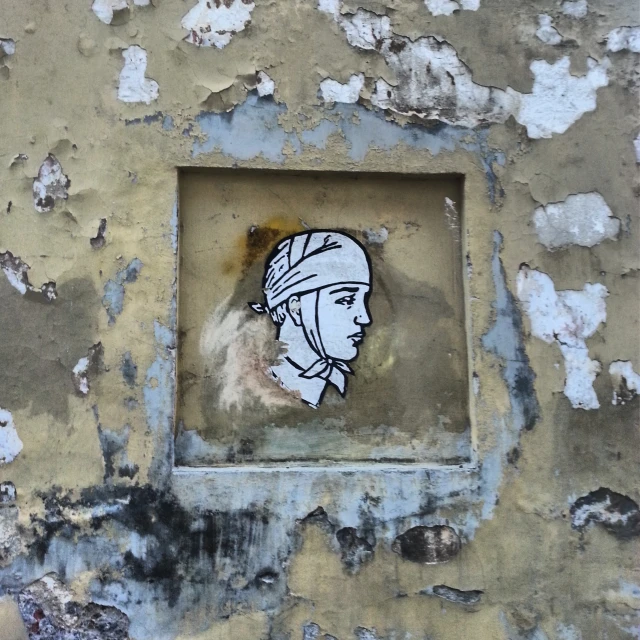a picture of a face on a piece of old stucco