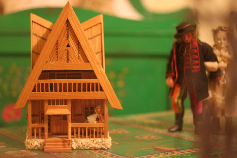 two people in toy figures stand inside a model house