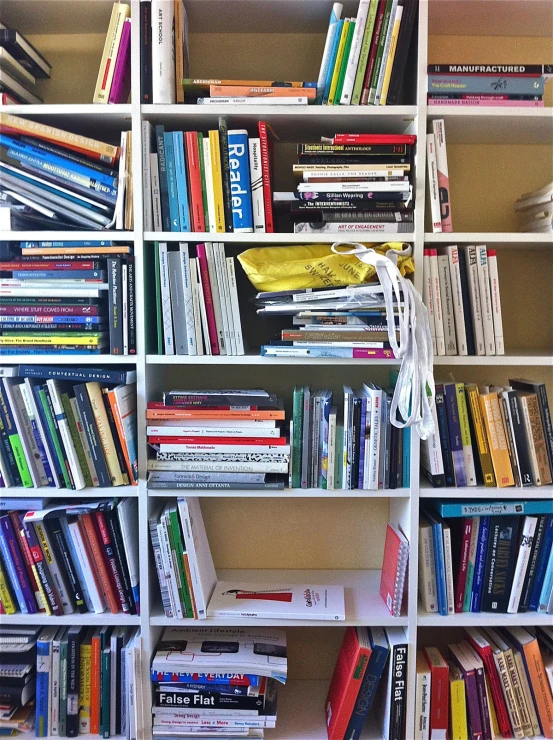 many books in a tall shelving unit are organized