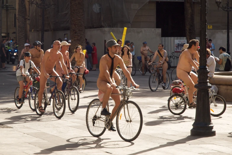  men riding their bikes down the street