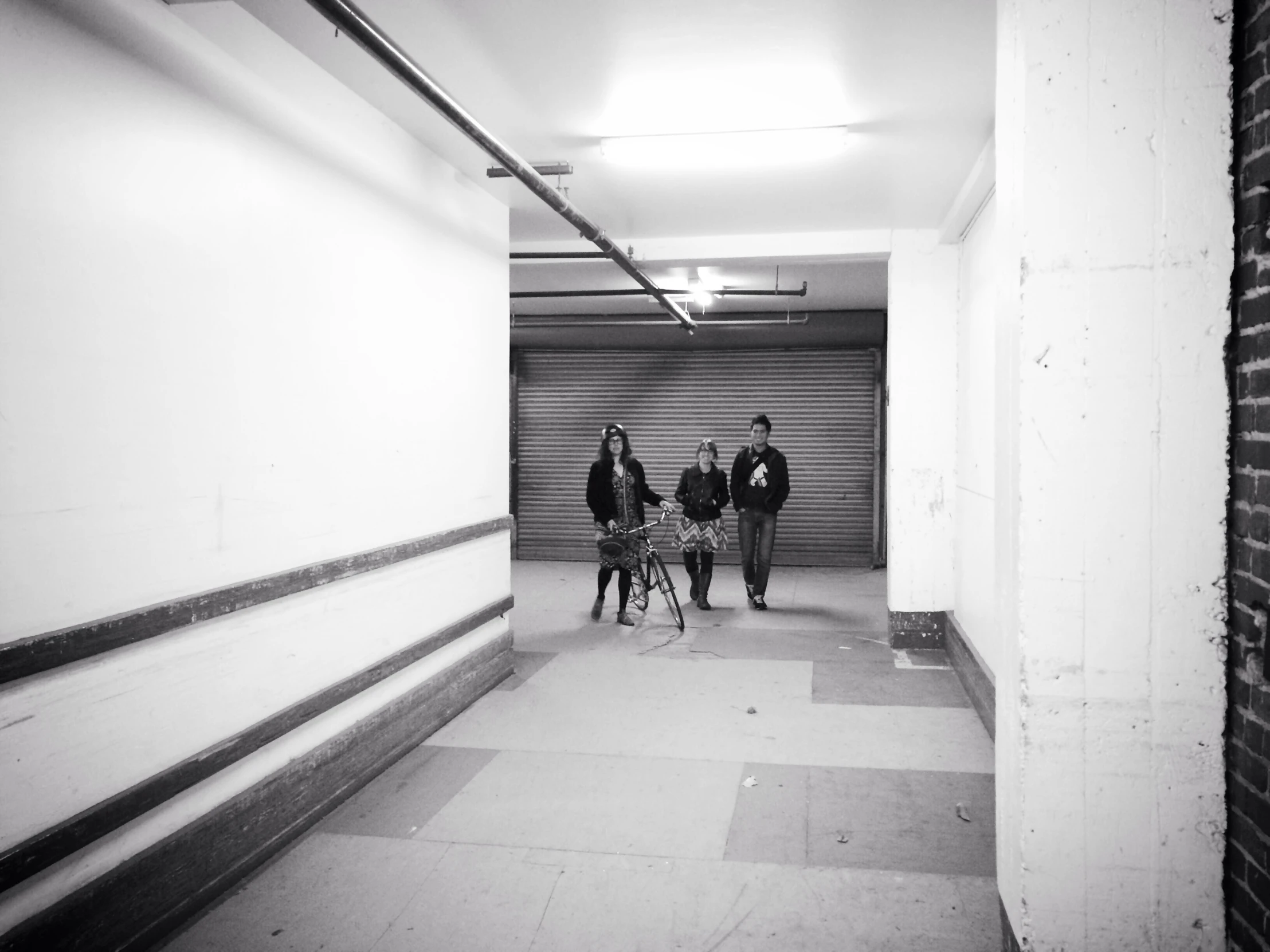 three people walking down a very long hallway