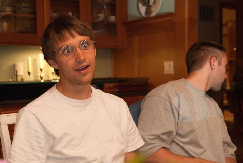 two men, one with glasses on, look at the camera
