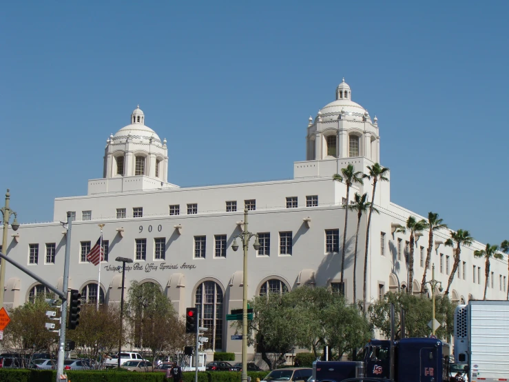 the large building is white and has palm trees