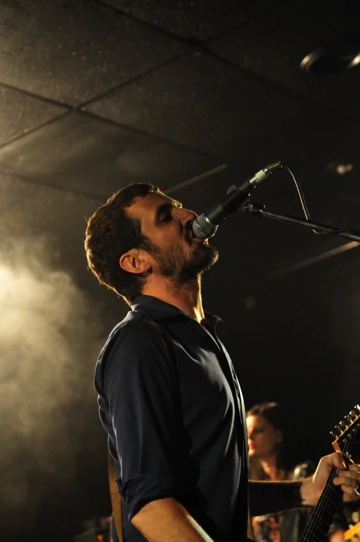 a man with a beard holding a guitar