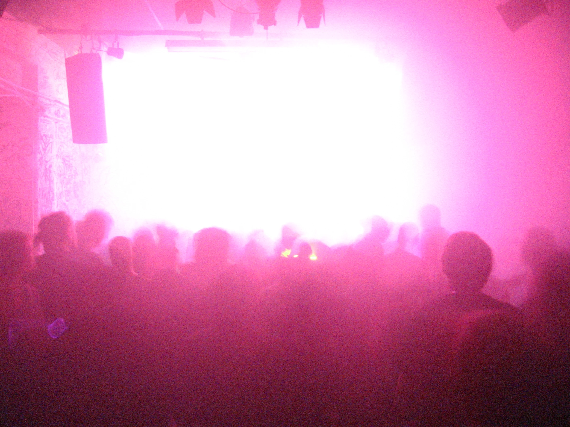 the front of a group of people at an event with pink light