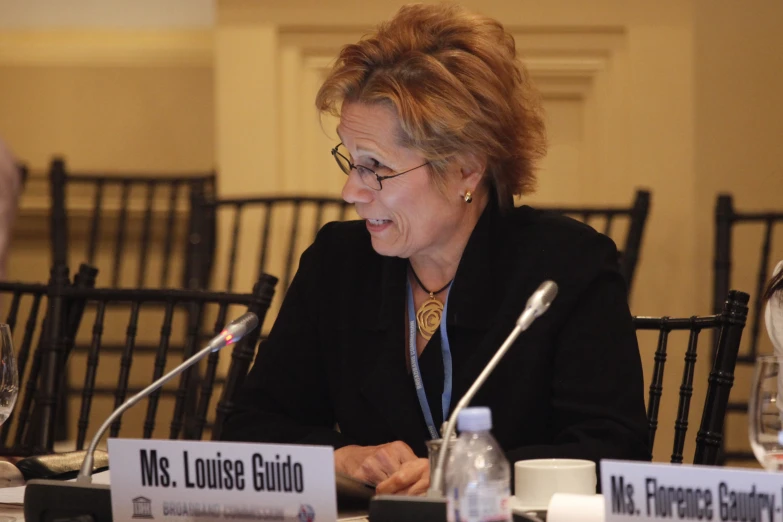 a lady sitting at a table at an executive meeting