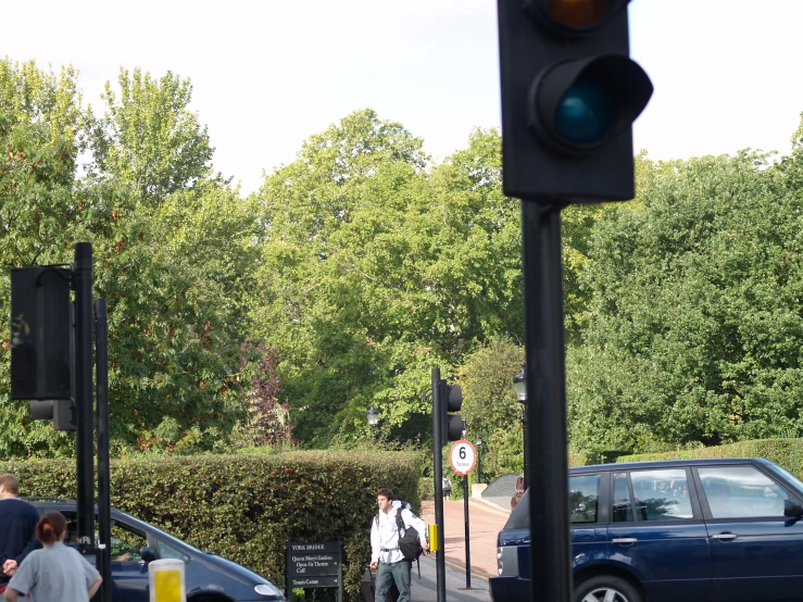 some cars and people are walking around in a city