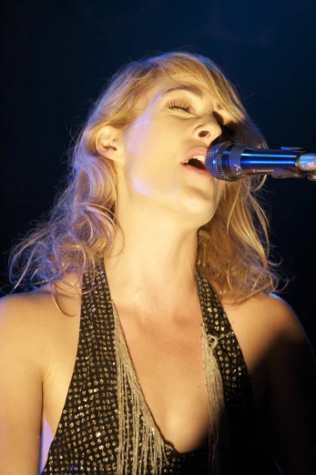 a person is singing into a microphone on stage